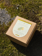 Brown cardboard box with a label on a mossy surface